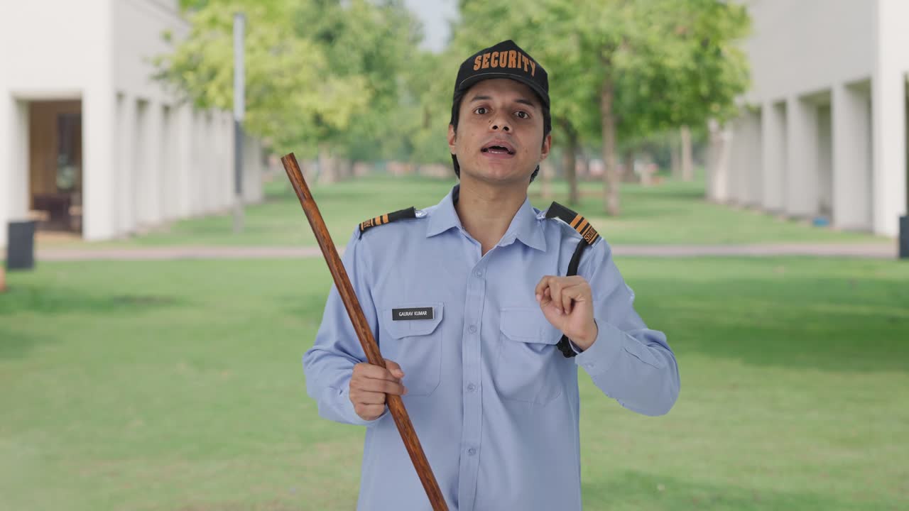인도 보안 경비원 이 누군가 에게 방향 을 알려 주고 있다