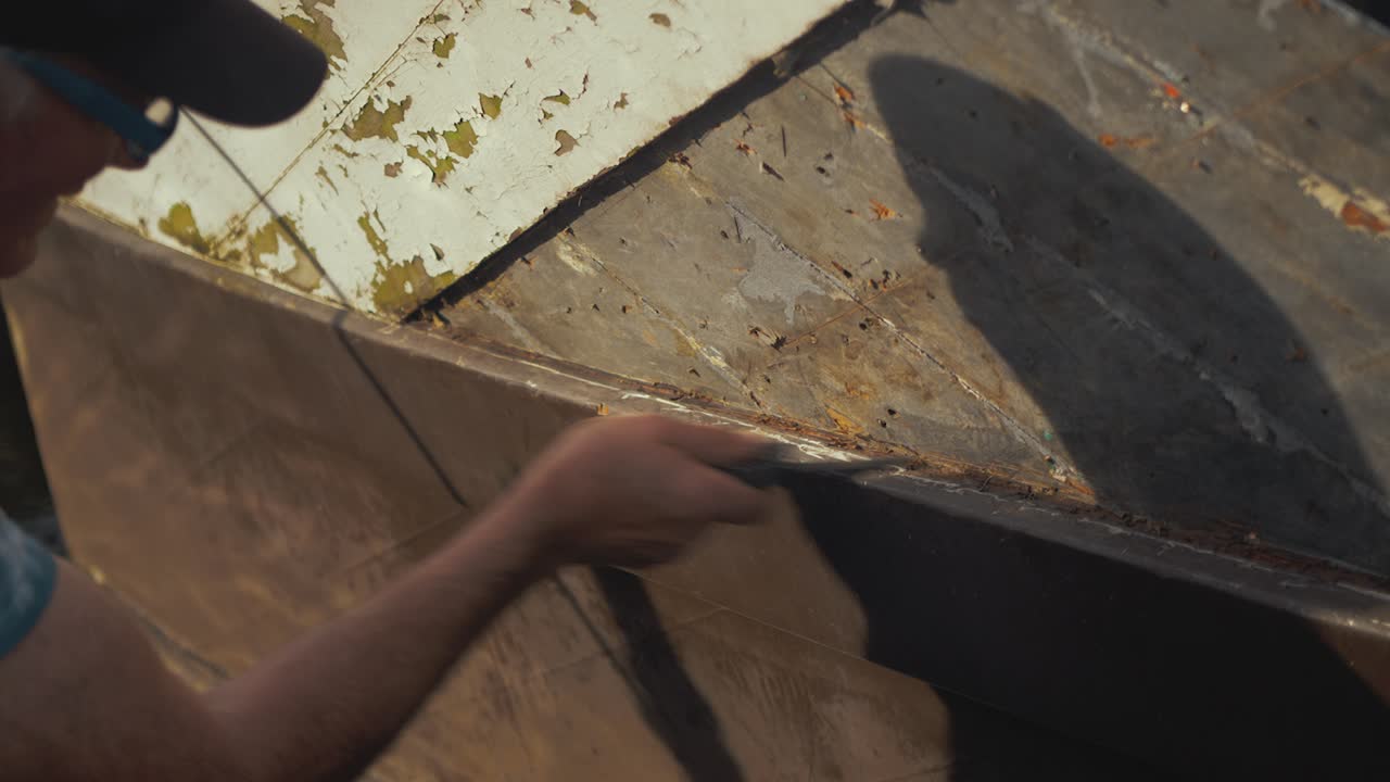 Carpenter cleaning double diagonal planking with knife of Seaplane Tender boat