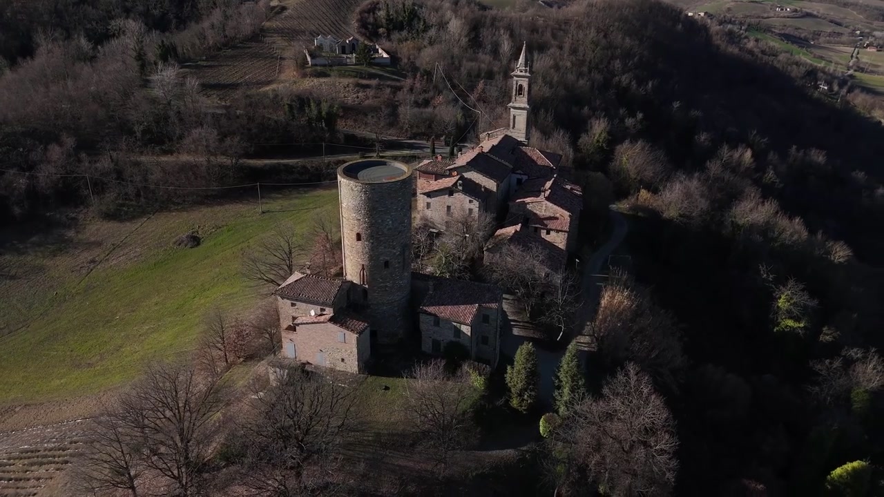 Castello di Monteventano med middelalderligt rundt borgtårn og Kirken Nativita della Beata Vergine Maria har udsigt over Monteventano, Piozzano, Piacenza, Emilia-Romagna, Italien, droneoptagelse