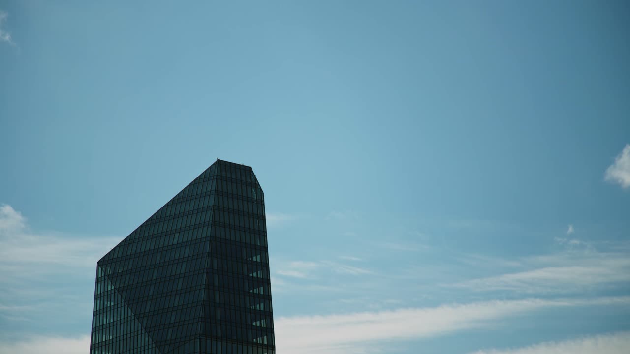 Torre Diamante de Milán contra un cielo azul con nubes esponjosas, en lapso de tiempo.