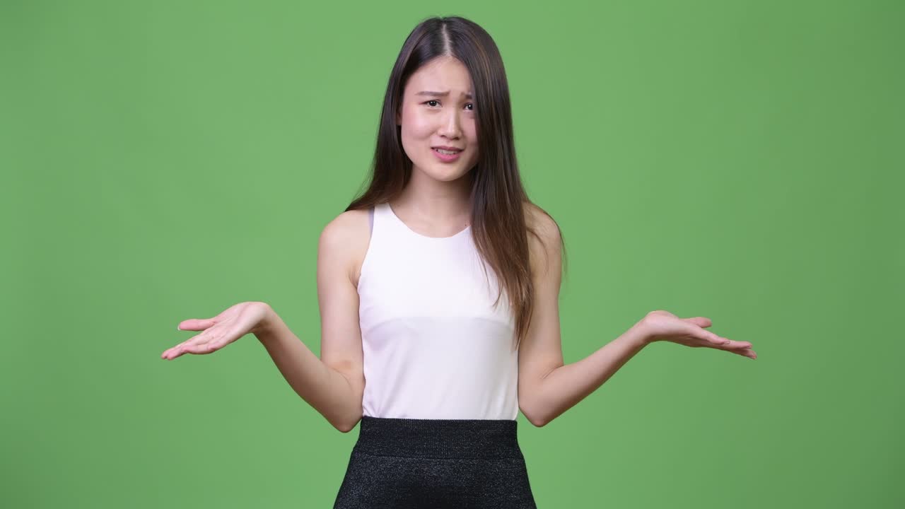 Young beautiful Asian businesswoman shrugging shoulders
