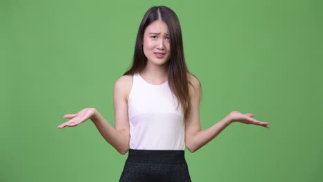 young beautiful asian businesswoman shrugging shoulders