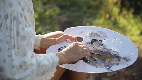 a young girl paints a picture while sitting in tall grass professional artist - a young girl paints a picture while sitting in tall grass. professional artist, art, inspiration in nature