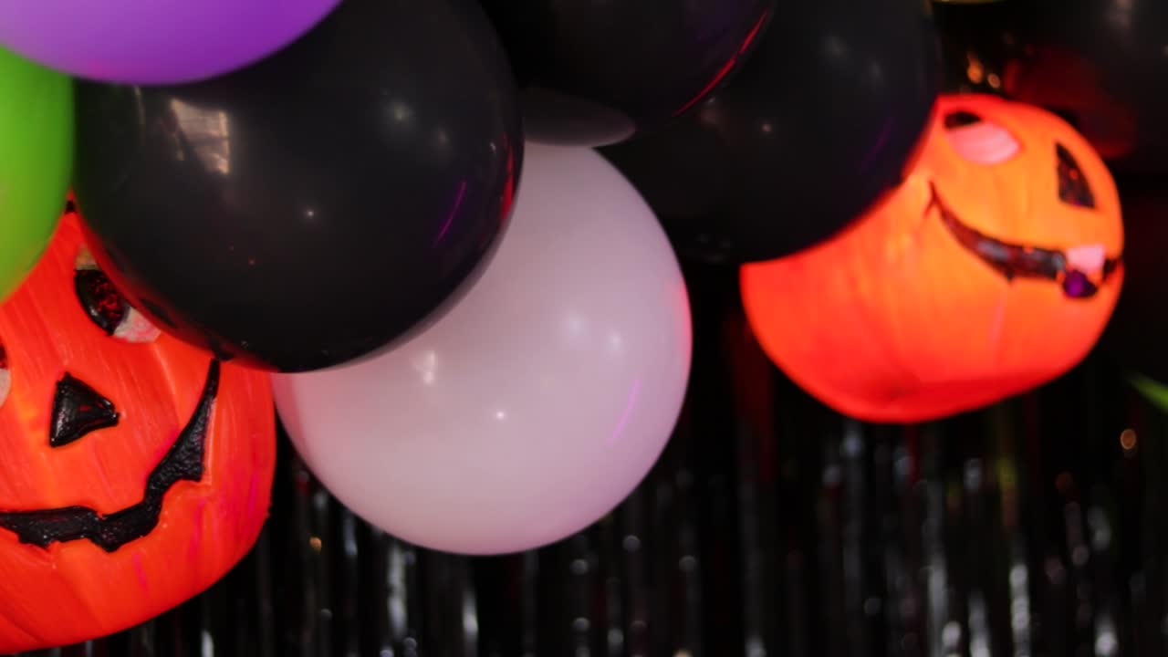 vibrantes globos de halloween agrupados alrededor de una calabaza sonriente