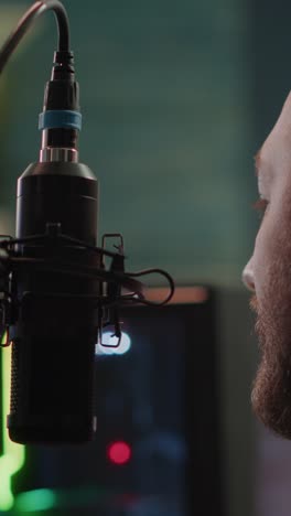 close-up of a man speaking into a professional studio microphone