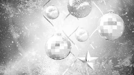 animation of snow falling over silver christmas baubles decorations