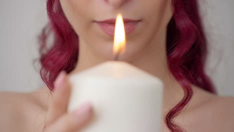 attractive red hair woman looking towards candlelight, close up front view