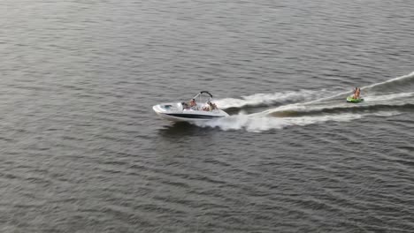 lancha motora tirando de un bote pequeño, cruzando el mar durante el día