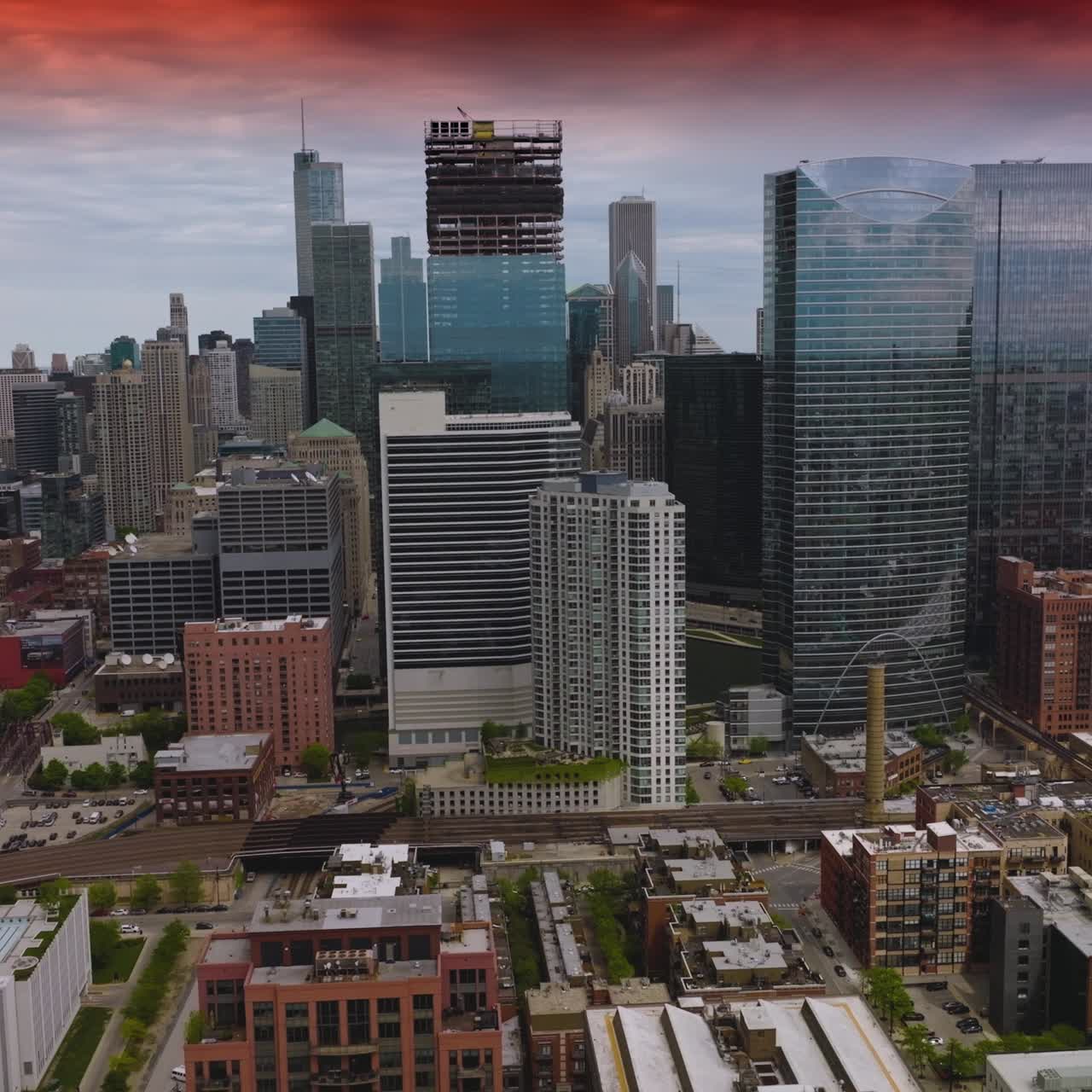 Amazing contemporary architecture of Chicago under the red skies. Majestic skyscrapers neighboring usual multi-storied buildings in metropolis. Aerial view