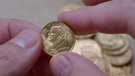 person holding polished golden twenty franc coin from year 1947,close up