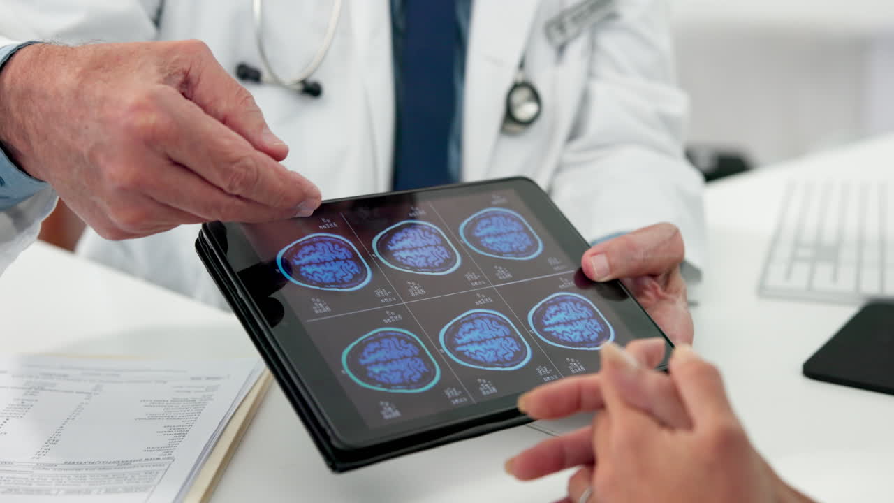 Médico discutiendo escáneres cerebrales en tableta digital con paciente