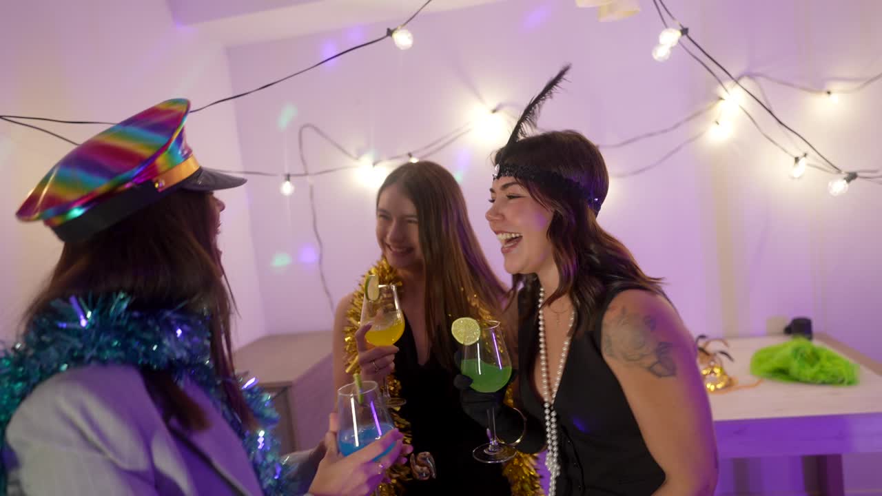 Tre donne che festeggiano con cocktail e abiti festivi