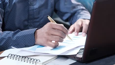 businessman analyzing data and charts on laptop