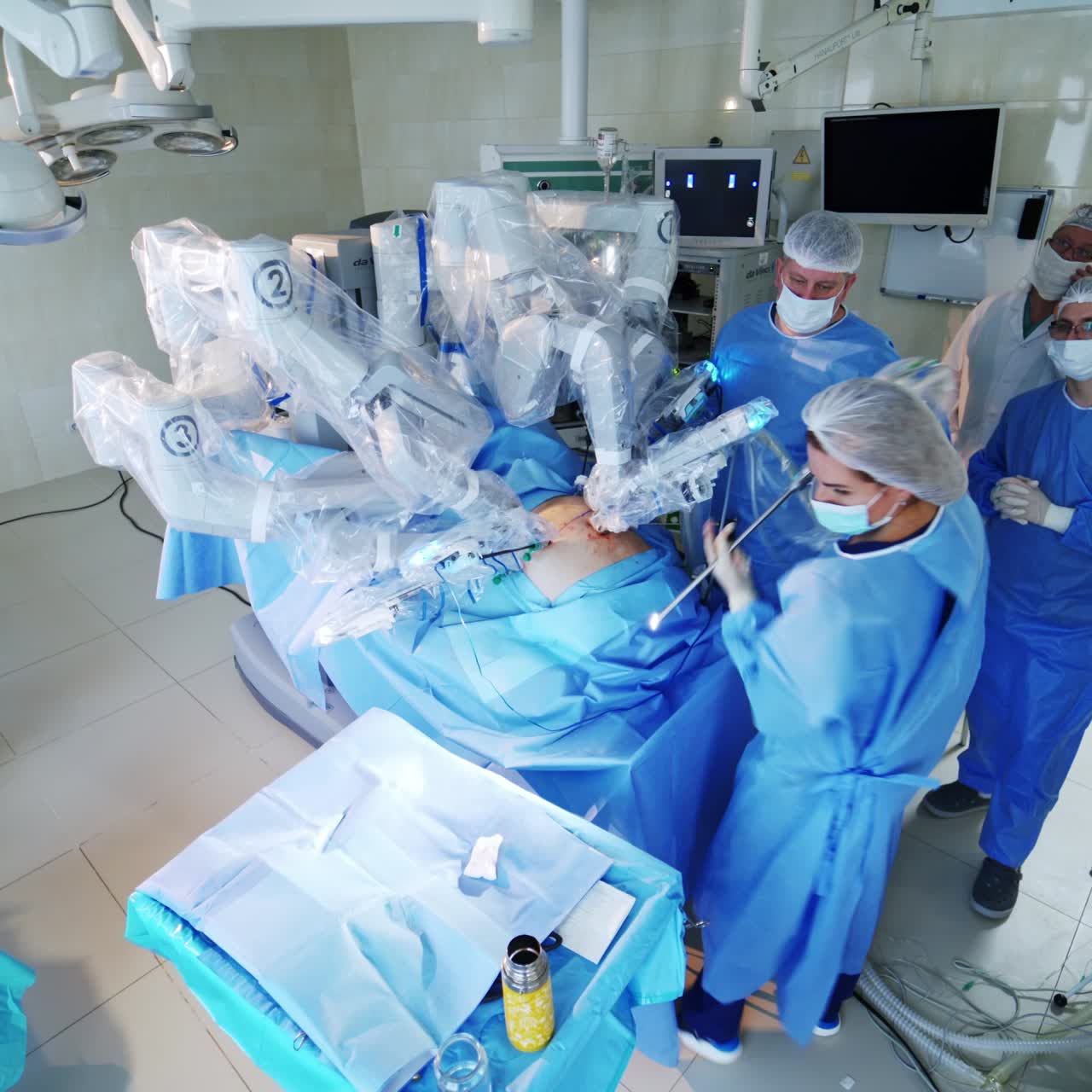 Medical team of surgeons near the futuristic robotic machine. High-tech surgery with robotic equipment in the modern operating theater.