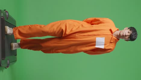 cuerpo lleno de prisionero masculino asiático en esposas caminando en el fondo de la pantalla verde