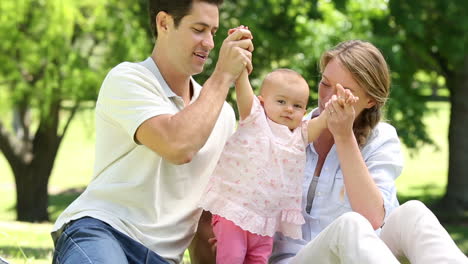 happy parents with their baby girl in the park