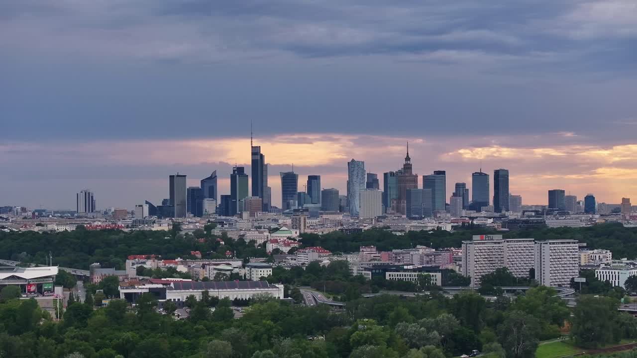 Sunset in Warsaw from the Vistula River. Clouds in the sky behind the skyscrapers, golden hues visible