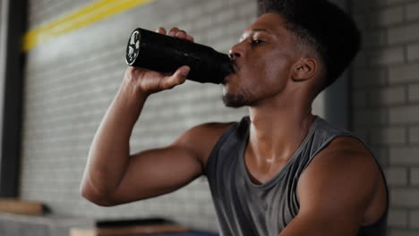 man drinking water after workout