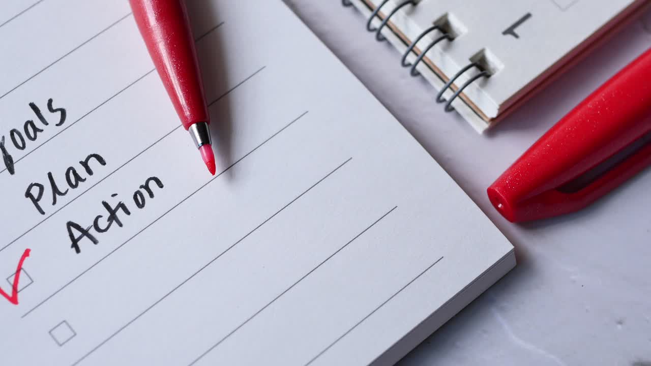 Tick mark on planning goals on notepad ,