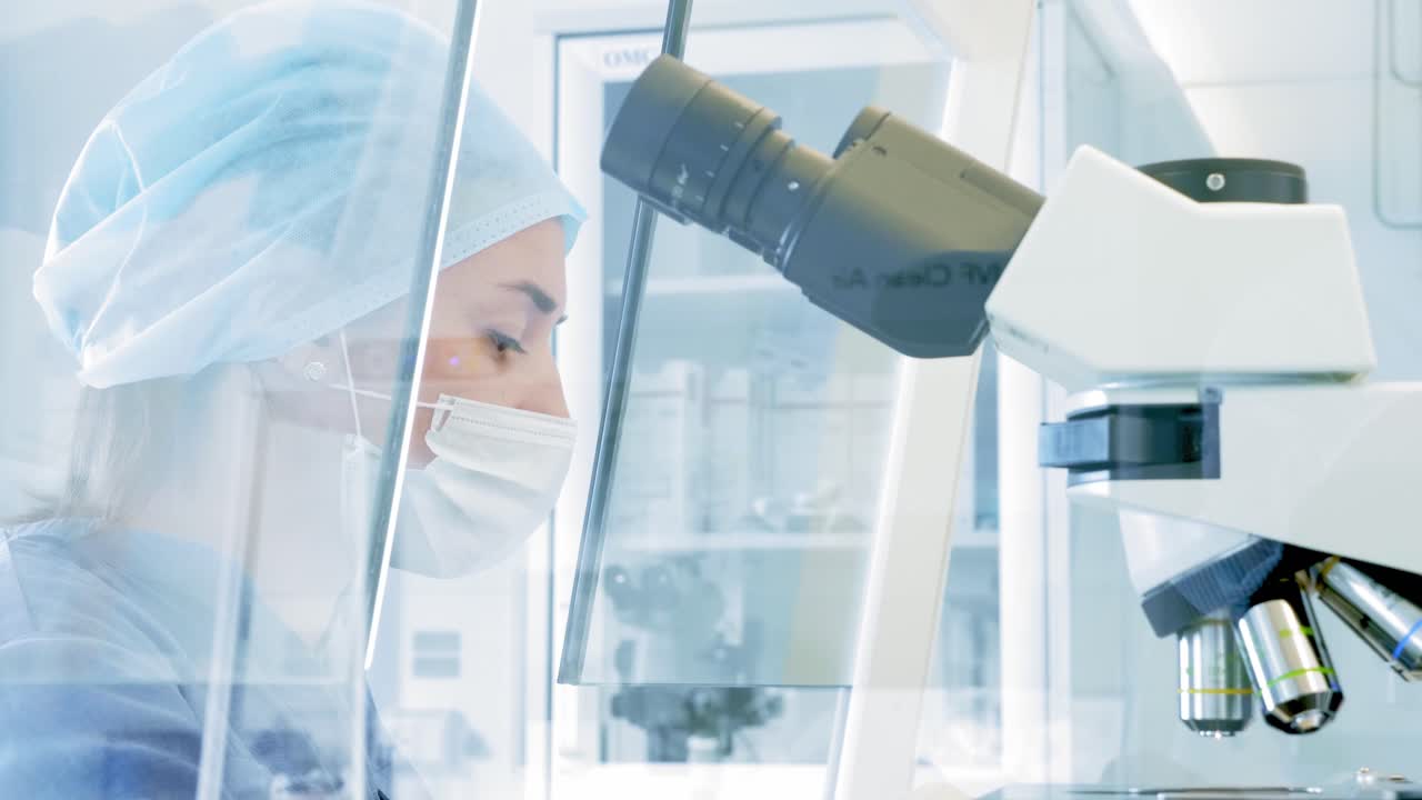 Scientist working with a microscope in a laboratory setting