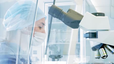 scientist working with a microscope in a laboratory setting