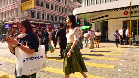 people crossing a bustling street in hong kong