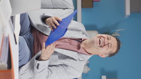 Vertical-video-of-Home-office-worker-old-man-looking-at-paperwork-files.