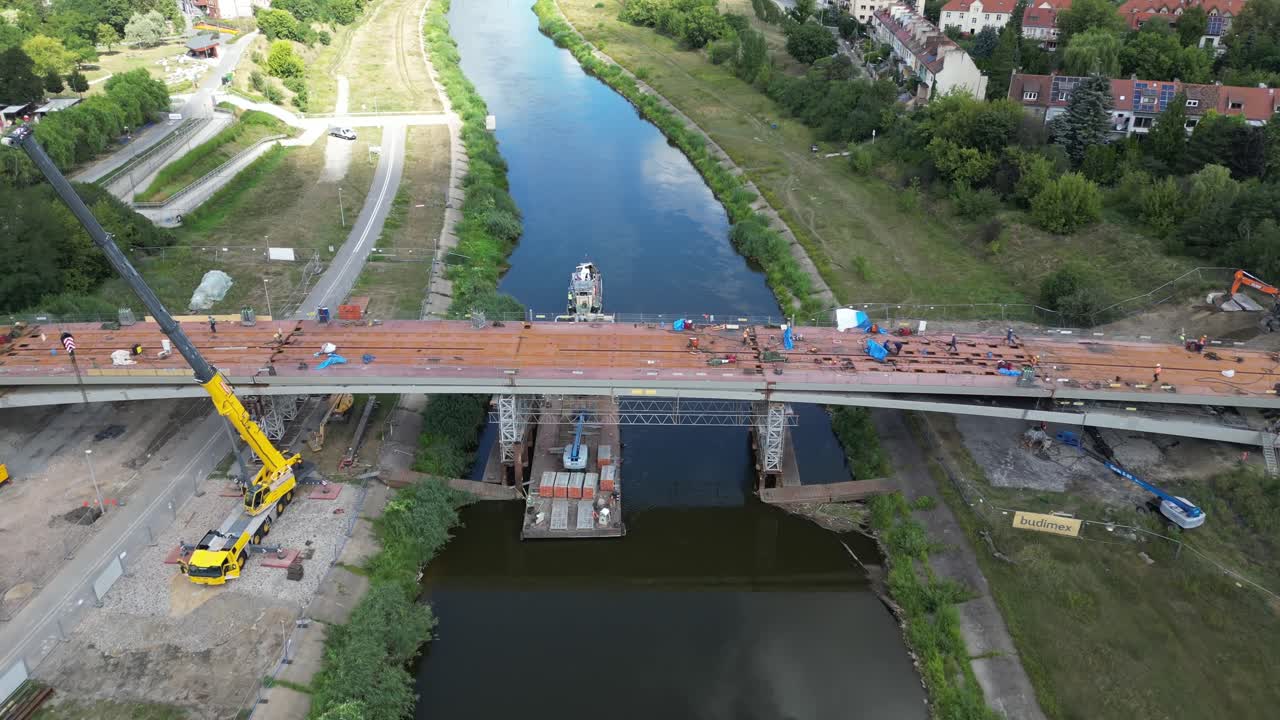 Aerial view, flyover of the construction site of bridge for pedestrian and bicycles over Warta river in Poznan Poland during summer sunny day.