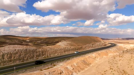 car heading south on a desert highway with cloudy blue sky