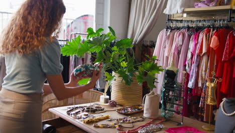 woman in fashion clothing store shopping for accessories or arranging display