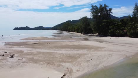 AERIAL:-Drone-is-Traveling-Low-Above-the-Low-Tide-Сoastline-with-Jungles-on-the-left-side