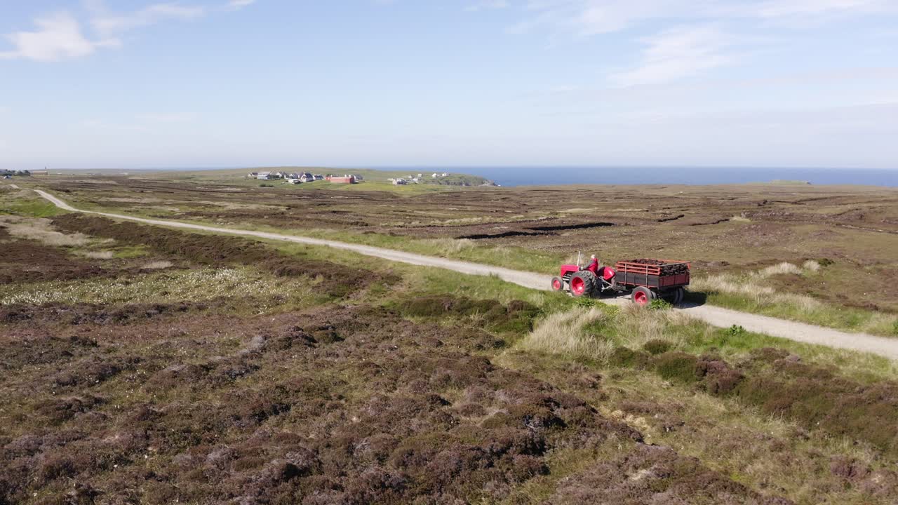 그의 이탄지에서 이탄 수확을 집으로 운전하는 이탄 절단기의 트랙터를 따라 드론 샷