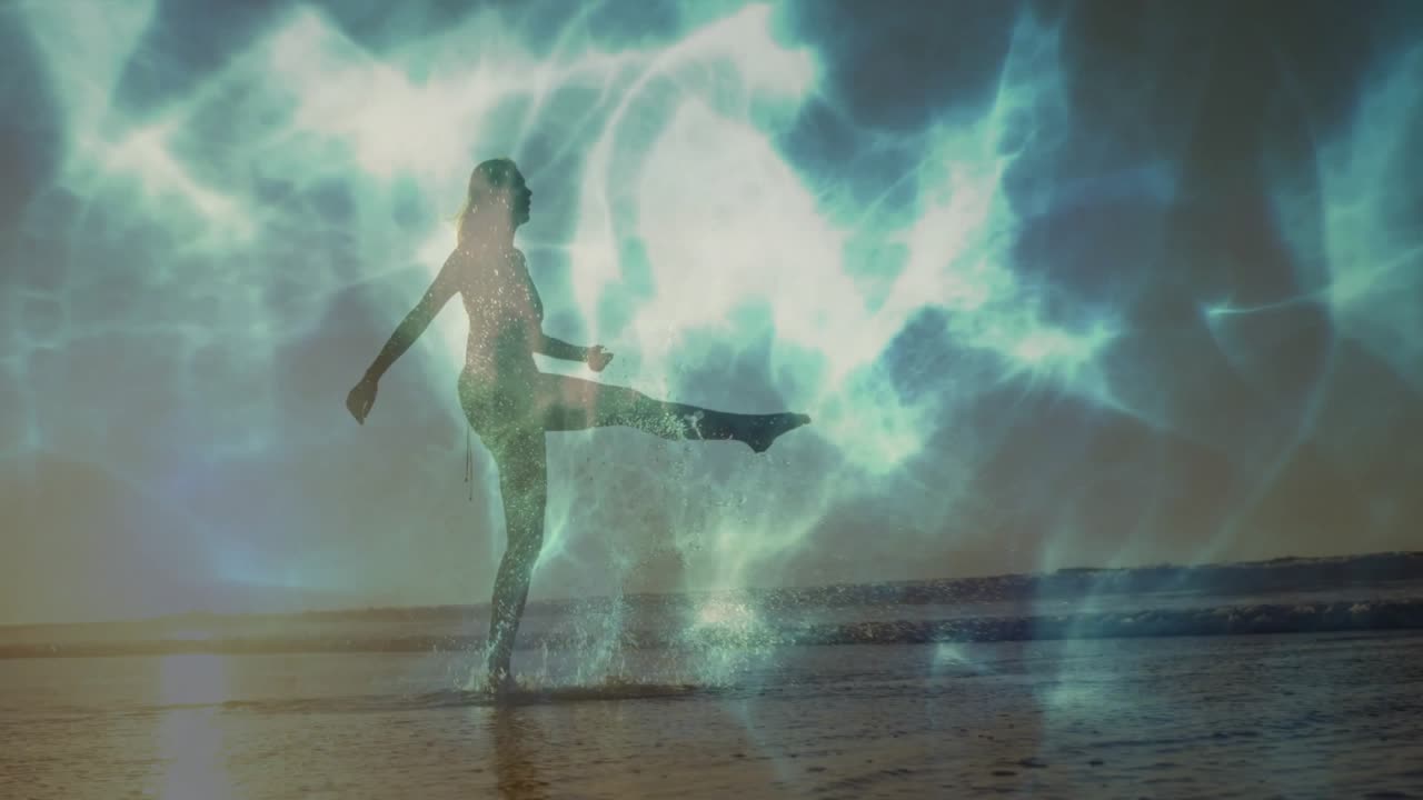 La marea che trascina una ballerina di fitness sulla sabbia bagnata mentre luci verde acqua pulsano e spruzzi d'acqua volano.