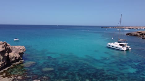 Couple-Waving-and-Operating-Drone-on-Vacations-in-Paradise-Beach,-Cyprus