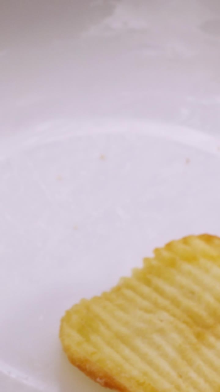 Golden Ruffled Potato Chips Falling and Piling Up