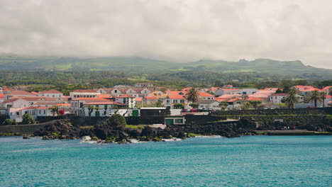 Pequeña-Ciudad-Local-Con-Tejados-De-Color-Naranja-Situada-En-La-Costa-Rocosa-De-Las-Islas-Azores,-Océano-Atlántico,-Portugal