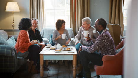 group of middle aged friends meeting around table in coffee shop