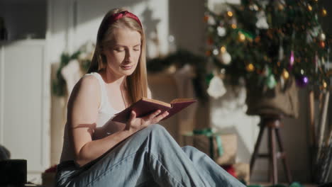 Schöne-Frau-Liest-Ein-Buch,-Während-Sie-Zu-Weihnachten-Zu-Hause-Sitzt