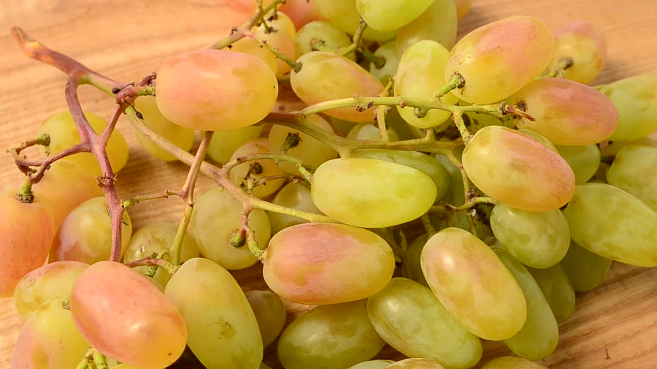 Uva su un tagliere da cucina. Ripresa in movimento