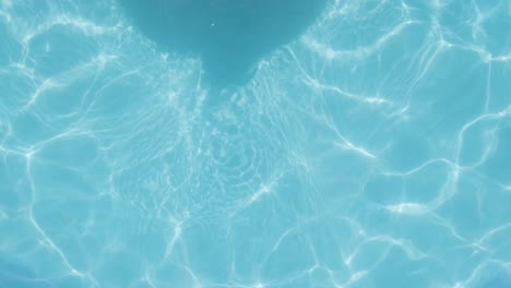 Topdown-view-Boy-with-Smartphone,-Relaxing-on-a-Floater-in-Swimming-pool,-Summer-concept