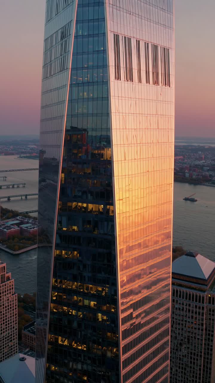 Ripresa video aerea di un moderno grattacielo al tramonto, che cattura l'architettura elegante e il paesaggio urbano.
