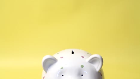 hand puts a hundred dollar bill in a piggy bank.4k