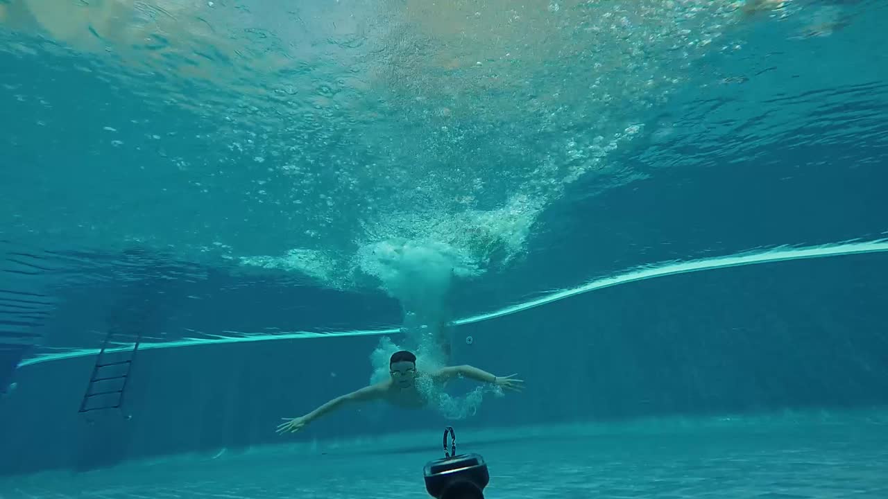 Person diving underwater in a swimming pool