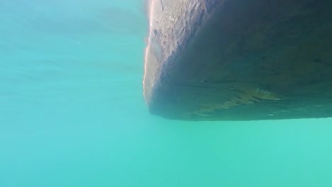 traditional wood boat running at river clear water underwater view