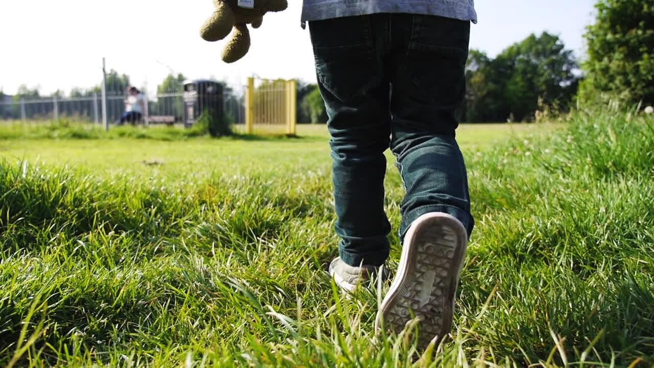 슬로우 모션으로 녹색 필드를 걷는 아이