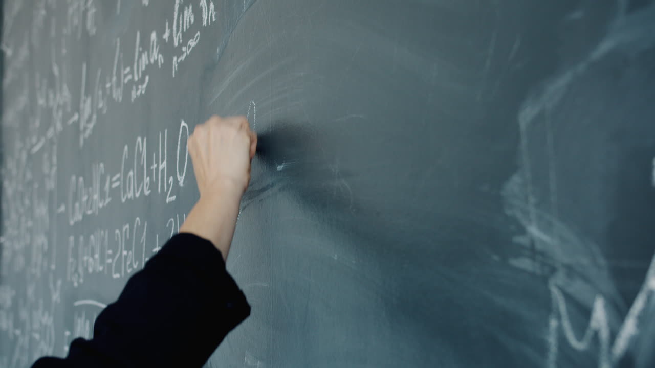 Teacher writing on chalkboard