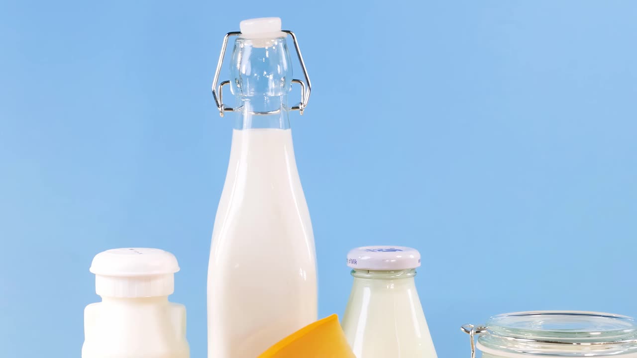 A variety of dairy products including milk, cheese, and yogurt displayed against a blue background.