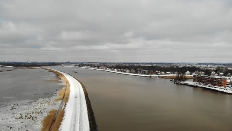 Frostiger-Crezeepolder-Und-Fluss-Noord-Mit-Frachtschiff,-Das-In-Der-Nähe-Von-Ridderkerk-In-Den-Niederlanden-Segelt