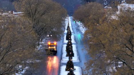 long aerial zoom of snow flurries falling on small town in america