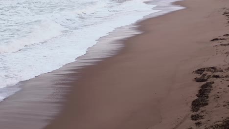 footage of sea waves splashing into a majestic sandy beach n on the coastline shores